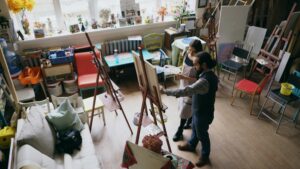 Image of two people working on a piece of artwork in a studio